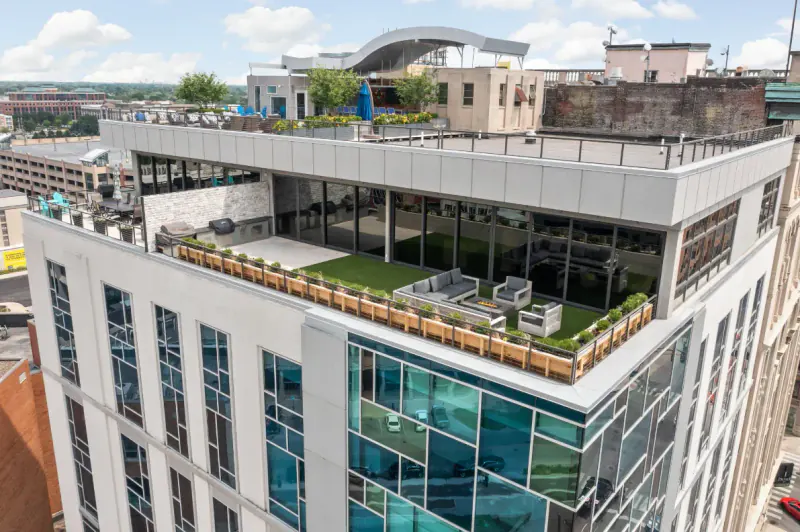 Aerial view of a penthouse rooftop terrace with turf, lounge seating and planter boxes